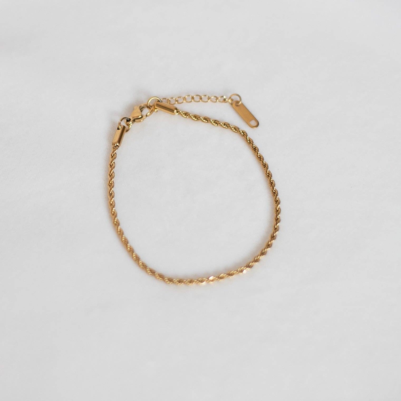 Delicate gold chain bracelet with an adjustable clasp, displayed flat on a light background