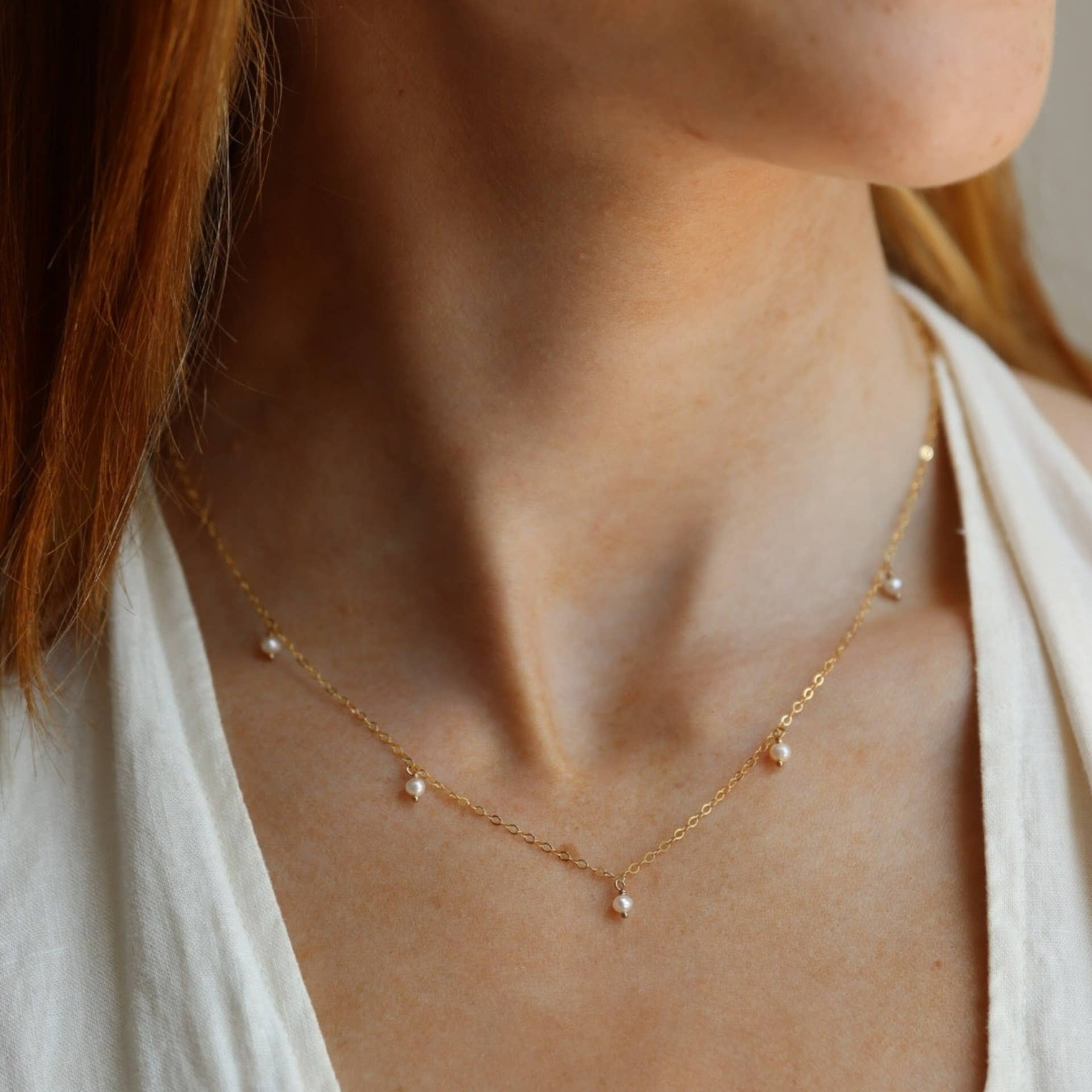 Delicate gold chain pearl necklace worn by a model, showcasing its elegant and minimal design